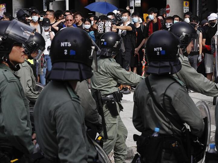 Bereitschaftspolizisten stehen Demonstranten bei dem Protest im Bezirk Yuen Long gegenüber.