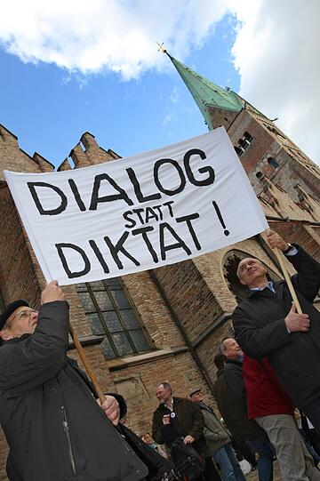 Katholiken stehen am Samstag (21.04.2012) mit Transparenten auf dem Domplatz von Augsburg (Schwaben). Im Rahmen einer Kundgebung demonstrieren sie gegen die geplante Pastoralreform des Bistums Augsburg.