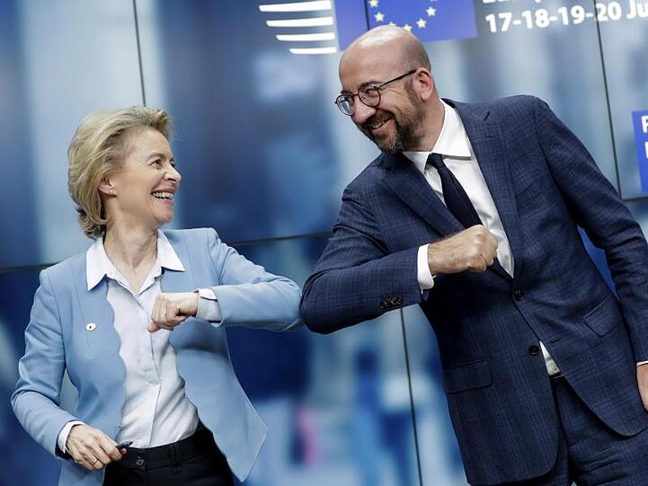 Kommissionspräsidentin Ursula von der Leyen und Ratspräsident Charles Michel gratulieren sich mit einem Ellenbogen-Stoß.