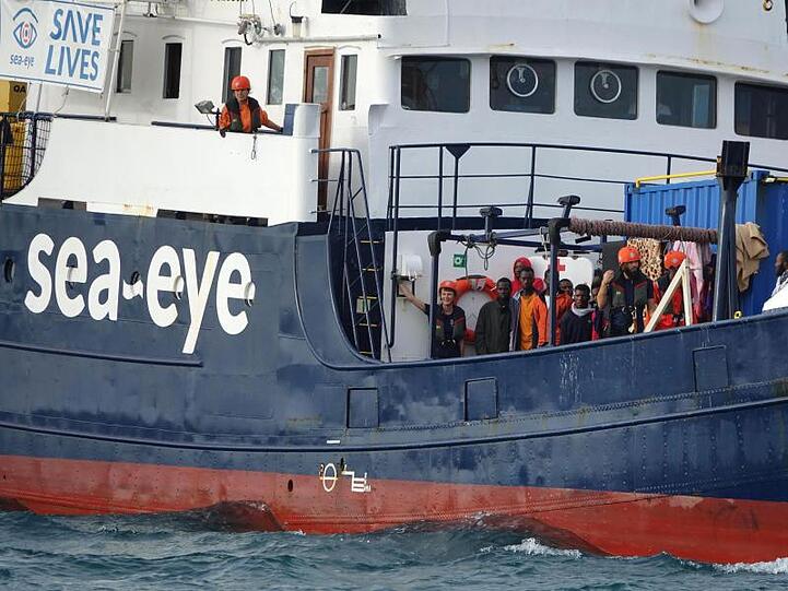 Migranten und Besatzungsmitglieder stehen an Deck des deutschen Rettungsschiffs "Alan Kurdi". (Symbolbild)