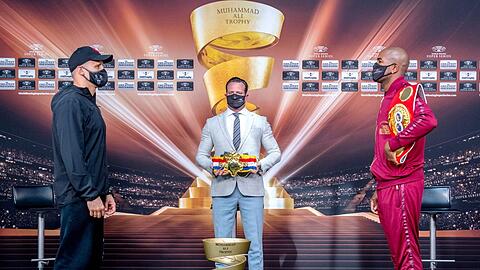 Wer ist der beste Cruisergewichtler der Welt? Mairis Briedis (l.) oder Yuniel Dorticos (r.). Promoter Kalle Sauerland präsentiert Gürtel und Pokal.