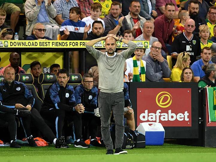 Trainer Guardiola steht an der Seitenlinie und fasst sich aufgrund der Niederlage gegen Norwich City an den Kopf.