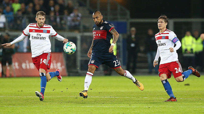Das Hinspiel in Hamburg gewann der FC Bayern mit 1:0 - hier wird Arturo Vidal von den HSV-Profis Aaron Hunt und Gotoku Sakai verfolgt.