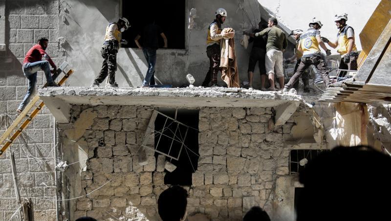 Menschen stehen vor einem Gebäude, das bei einem Luftangriff am 27. Mai durch die syrischen Regierungskräfte beschädigt wurde. Menschen stehen vor einem Gebäude, das bei einem Luftangriff am 27. Mai durch die syrischen Regierungskräfte beschädigt wurde.
