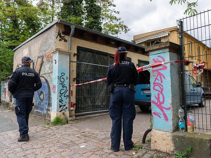 Polizisten sichern die Einfahrt des Hauses im Stadtteil Neustadt.