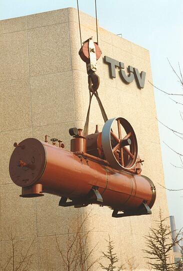 1982 wird eine alte Dampfmaschine vor das Tüv-Gebäude gehoben.