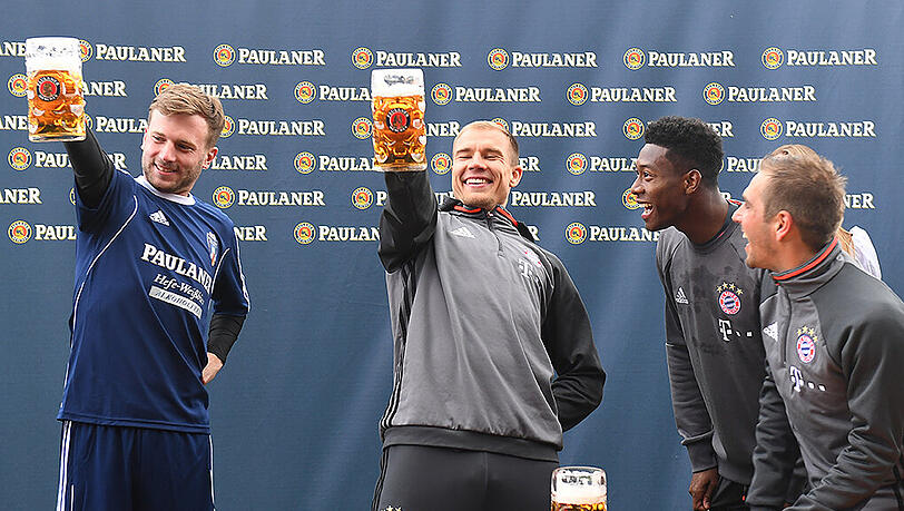 Feuern ihren Teamkollegen Holger Badstuber (M.) beim Maßkrugstemmen an: Philipp Lahm (r.) und David Alaba.