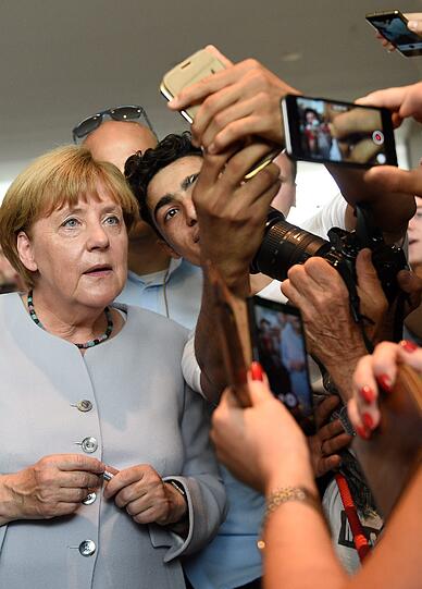 Die Kanzlerin ganz bürgernah: Angela Merkel posiert am Tag der offenen Tür im Bundeskanzleramt für Selfies mit Besuchern.