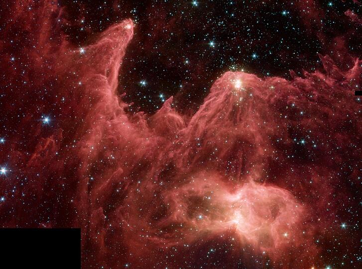 Die emporragenden Gassäulen werden vom Licht neuer Sterne erhellt, festgehalten vom Spitzer-Teleskop.