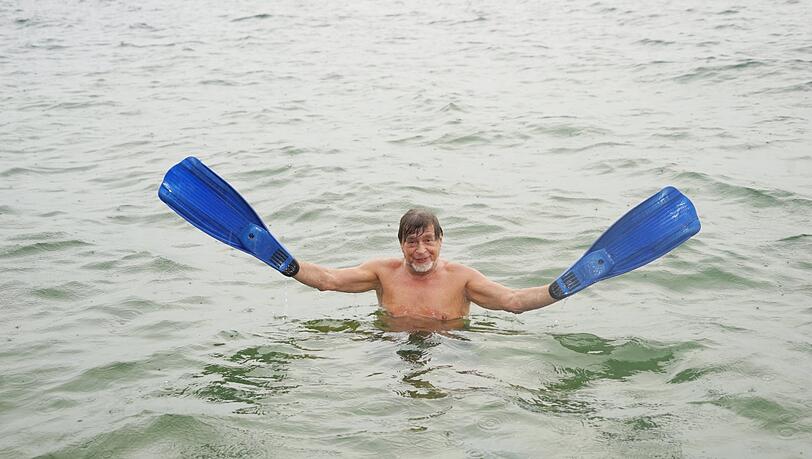 Nikolai Tregor mit seinen Flossen im Starnberger See, er schwimmt hier gerne mehrere Stunden.