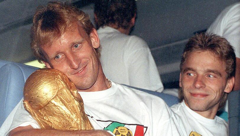 Andreas Brehme (l) mit dem WM-Pokal nach dem Finalsieg 1990 gegen Argentinien. Rechts daneben sein Mitspieler Thomas Häßler.