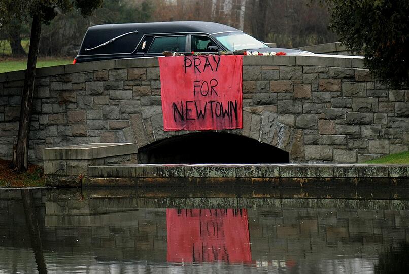 "Betet für Newtown" steht auf dem Plakat. Am Montag wurden die ersten Opfer nach dem Attentat an der Sandy-Hook-Grundschule in Newtown beerdigt. Der 20-Jährige Adam Lanza hat am Freitag erst seine Mutter erschossen und anschließend 26 Menschen in der Schule getötet.