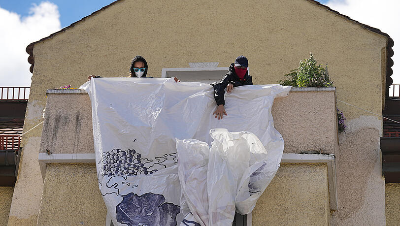 Demonstranten entrollen ein Anti-G7-Banner von einem Balkon. Demonstranten entrollen ein Anti-G7-Banner von einem Balkon.