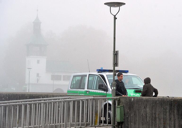 Ein Polizeiwagen steht auf einem Steg über dem Lech in Augsburg. Hier wurde in der Nacht auf Freitag bei einer Kontrolle ein Polizist erschossen.