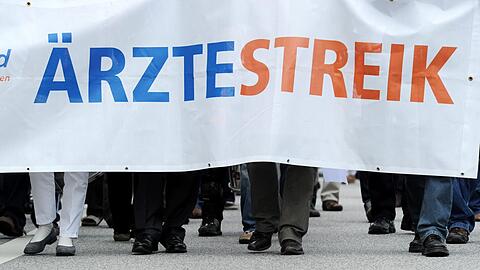 Mehrere hundert streikende Klinikärzte ziehen in einem Protestmarsch durch die Innenstadt.