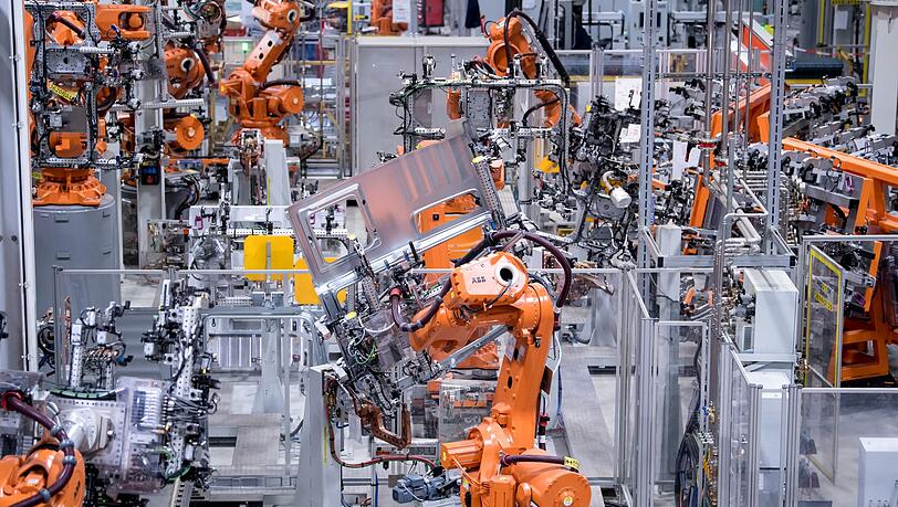 Roboter in einer Werkshalle von MAN Truck & Bus. Die bayerische Metall- und Elektroindustrie hat magere Jahre hinter sich. (Archivbild)