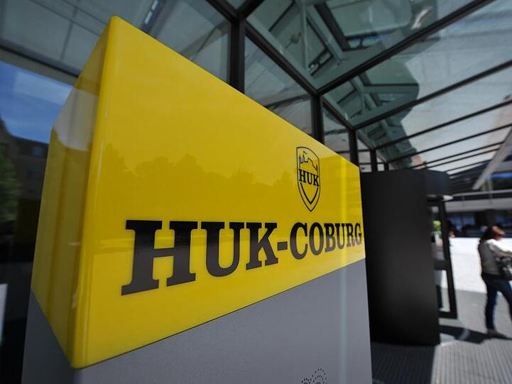 Eine Frau verlässt den Unternehmenssitz der HUK-Coburg Versicherungsgruppe. Foto: David Ebener/dpa/Symbolbild