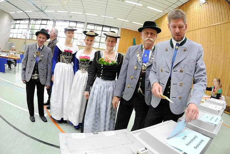 Ein Trachtler wirft am 15.09.2013 in Großhelfendorf (Bayern) einen Stimmzettel zur Landtagswahl in Bayern in die Wahlurne.