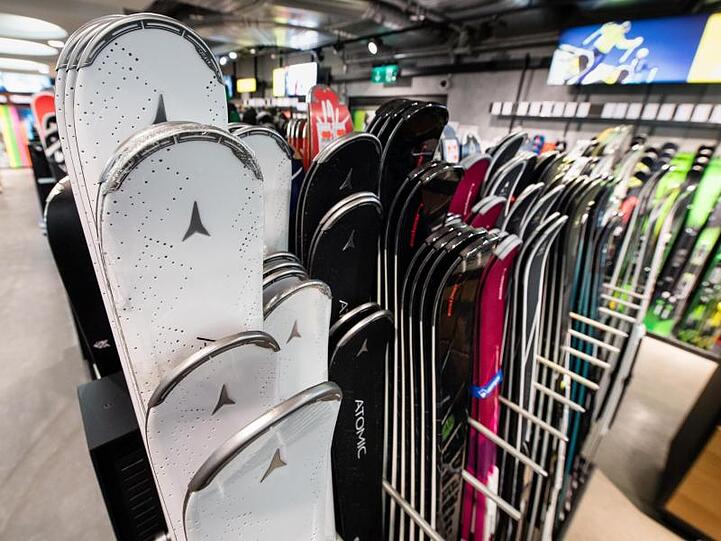 Skier verschiedener Hersteller sind am in einem Sportgeschäft zu sehen.