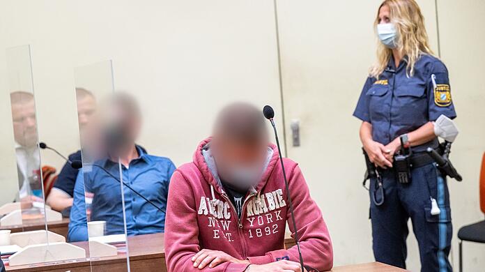 Der Hauptangeklagte (vorne) und ein weiterer Angeklagter sitzen beim "Blood & Honour"-Prozess mit ihren Anwälten im Gerichtssaal.