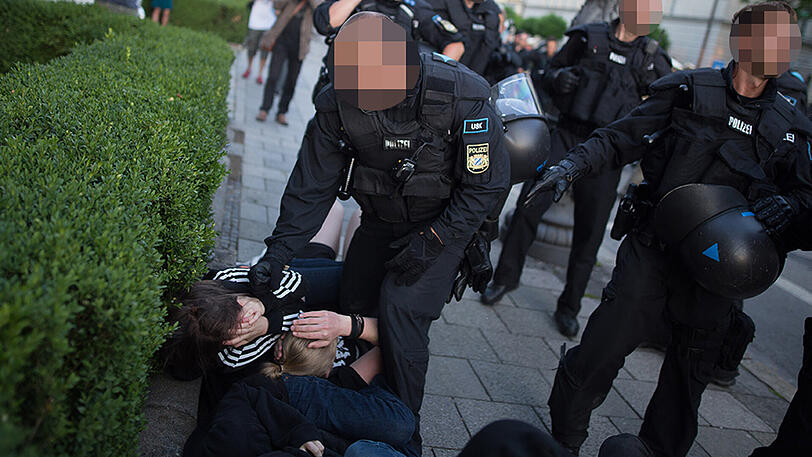 Der Polizist schlägt auf die junge Frau ein - die 18-Jährige liegt wehrlos am Boden.