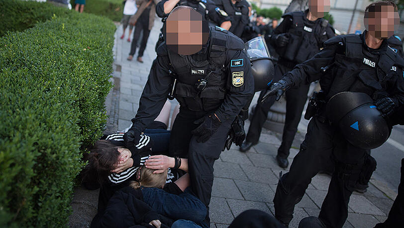 Der Polizist schlägt auf die junge Frau ein - die 18-Jährige liegt wehrlos am Boden. Der Polizist schlägt auf die junge Frau ein - die 18-Jährige liegt wehrlos am Boden.