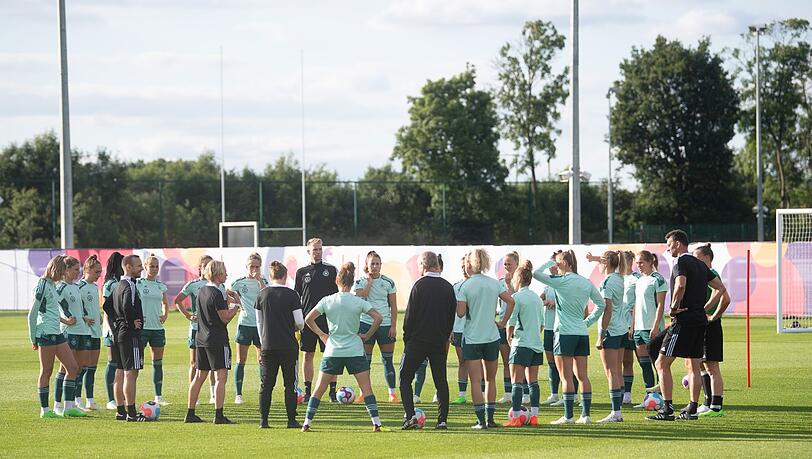 Spielerinnen und Bundestrainerin Martina Voss-Tecklenburg (l) sowie der Trainerstab stehen während einer Ansprache beieinander. Spielerinnen und Bundestrainerin Martina Voss-Tecklenburg (l) sowie der Trainerstab stehen während einer Ansprache beieinander.