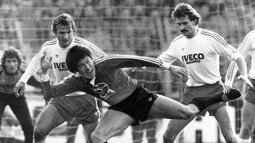 21. Januar 1984: Die Schale holt sich am Saisonende der VfB Stuttgart. Karl-Heinz Rummenigge wechselt anschließend zu Inter Mailand, Manager Uli Hoeneß baut die Mannschaft um &ndash; und führt die Münchner mit Udo Lattek in der neuen Spielzeit wieder zum Titel. In dieser Szene widmen sich Wolfgang Dremmler (links) und Bertram Beierlorzer (rechts) dem Leverkusener Südkoreaner Bum Kun Cha.