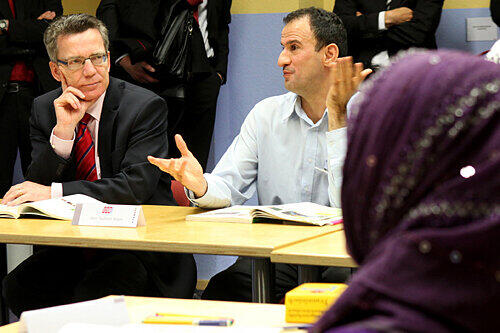 Bundesinnenminister Thomas de Maiziere (llinks) besuchte in Nürnberg einen Integrationskurs.