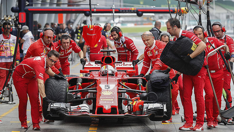Sebastian Vettel und sein Ferrari-Team beim Boxenstopp während des ersten freien Trainings. Sebastian Vettel und sein Ferrari-Team beim Boxenstopp während des ersten freien Trainings.