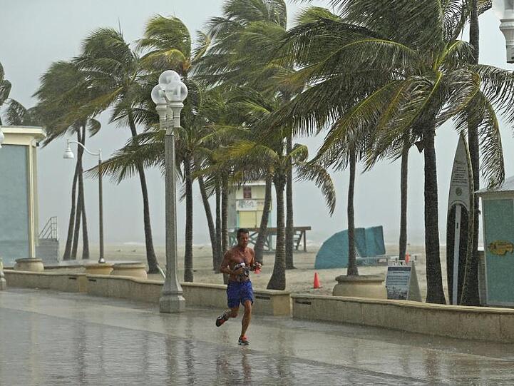 Ein Mann rennt am Hollywood Beach durch den Regen.