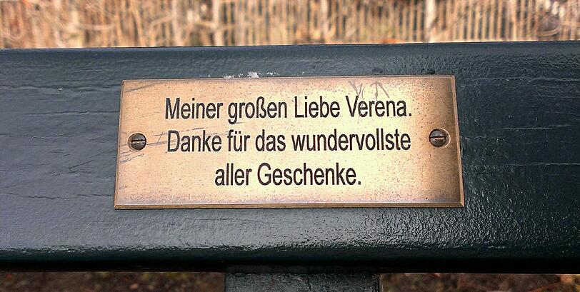 Im Englischen Garten und Nymphenburger Schlosspark haben Münchner tausende Plaketten mit Widmungen auf Parkbänken angebracht.