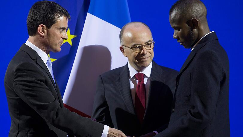 Lassane Bathily: Der 24 Jahre alte Flüchtling aus Mali erhielt am Dienstag in Paris von Ministerpräsident Manuel Valls seinen neuen Ausweis. Lassane Bathily: Der 24 Jahre alte Flüchtling aus Mali erhielt am Dienstag in Paris von Ministerpräsident Manuel Valls seinen neuen Ausweis.