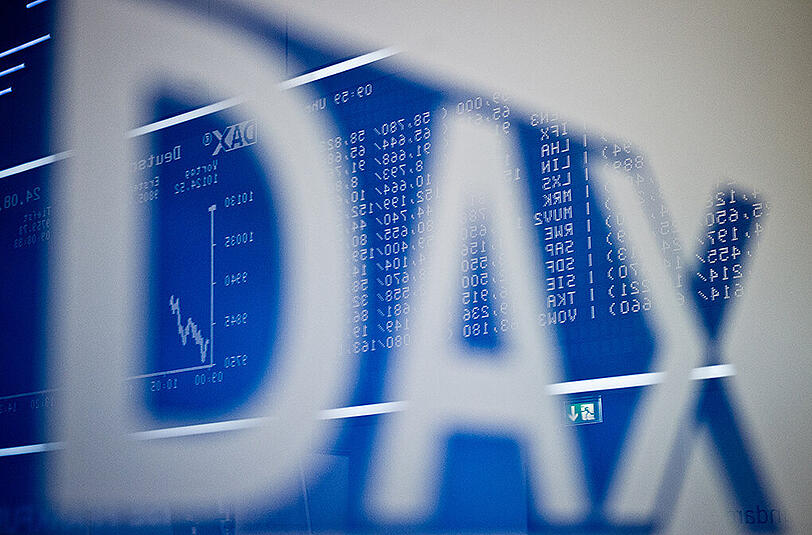 In der Börse in Frankfurt am Main spiegeln sich die aktuellen Zahlen in einem Logo des Deutschen Aktienindex (DAX). Foto: Christoph Schmidt