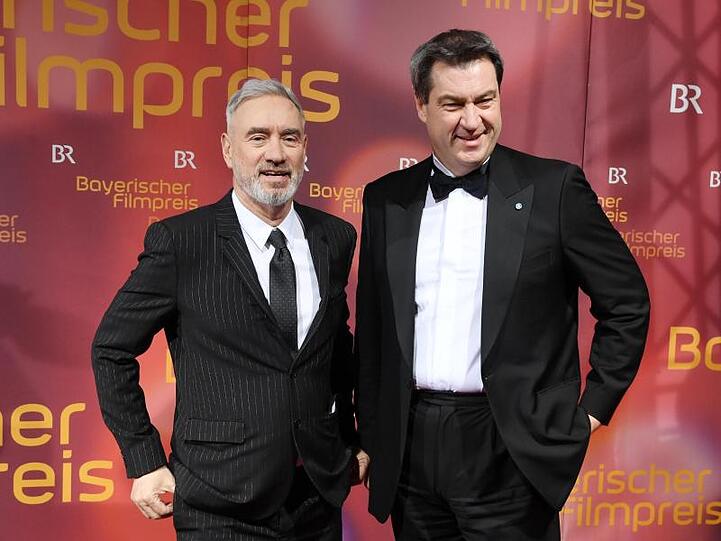 Regisseur Roland Emmerich (l.) und Ministerpräsident Markus Söder (CSU) kommen zur Verleihung des Bayerischen Filmpreises. Foto: Tobias Hase