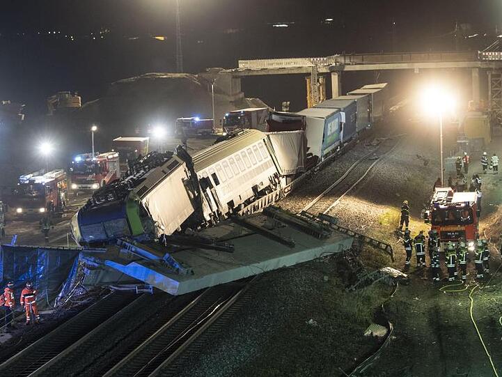 Feuerwehrfahrzeuge stehen um den verunglückten Zug.