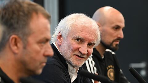 DFB-Sportdirektor Rudi Völler (M.) setzte sich bewusst zwischen Bundestrainer Hansi Flick (l) und U21-Coach Antonio Di Salvo.
