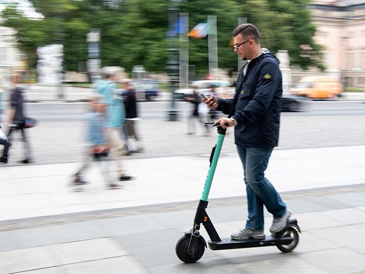 Auf zwei winzigen Rädern im Innenstadtverkehr, die Augen fest aufs Handy geheftet: Ein Tourist fährt durch Berlin-Mitte.