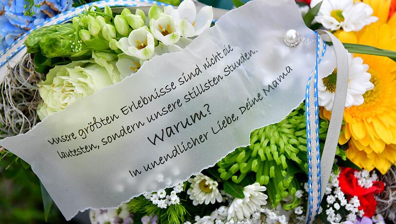 Blumengebinde von Angehörigen liegen an einer noch unbeschrifteten Grabsäule auf dem Friedhof. Blumengebinde von Angehörigen liegen an einer noch unbeschrifteten Grabsäule auf dem Friedhof.