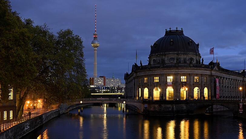 Der Fernsehturm und das Bode Museum spiegeln sich am Abend in der Spree.