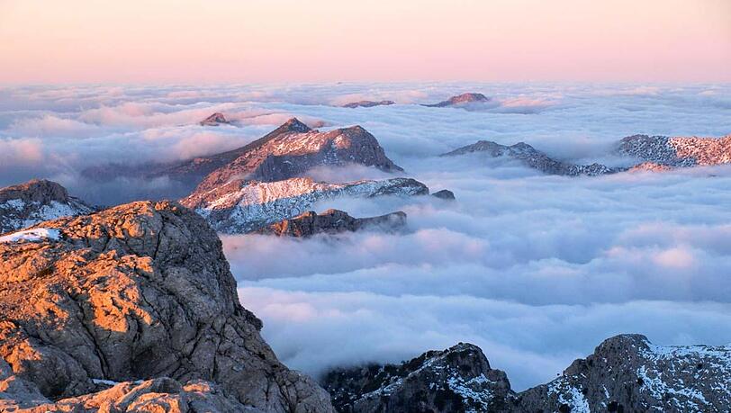 Einen malerischen Anblick bieten die in ein Wolkenmeer gehüllten Berggipfel am Puig de l'Ofre. Einen malerischen Anblick bieten die in ein Wolkenmeer gehüllten Berggipfel am Puig de l'Ofre.