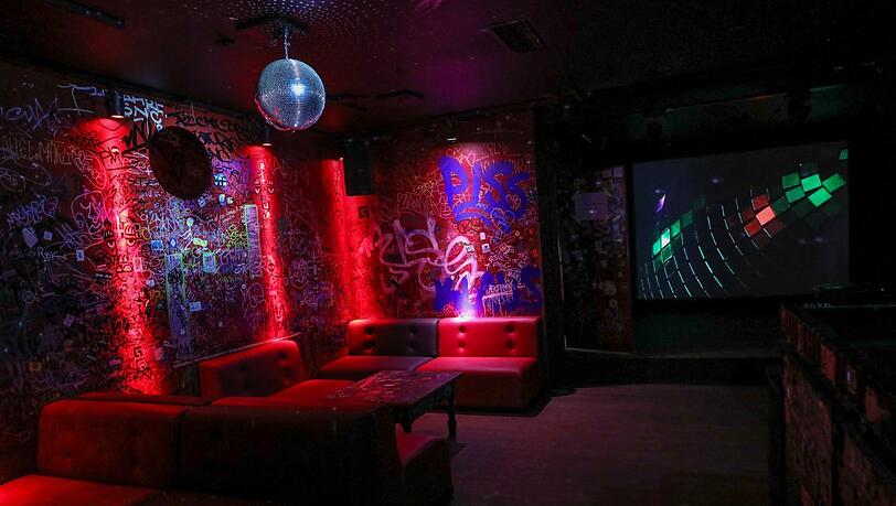 Links die Kritzelkunst der Bar Unter Deck, rechts die Video-Installation "Lights" von Wolfgang Tillmans.