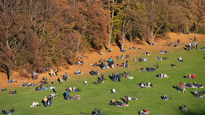 Zahlreiche Menschen entspannen bei Sonnenschein im Olympiapark. (Archivbild)