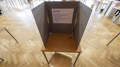 In einem Wahllokal steht eine Wahlkabine.