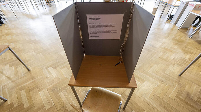 In einem Wahllokal steht eine Wahlkabine.