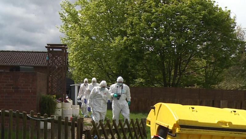 Mitarbeiter der Spurensicherung gehen durch den Garten des Wohnhauses, in dem eine 35-jährige Frau und ihr 4-jähriger Sohn tot aufgefunden wurden.