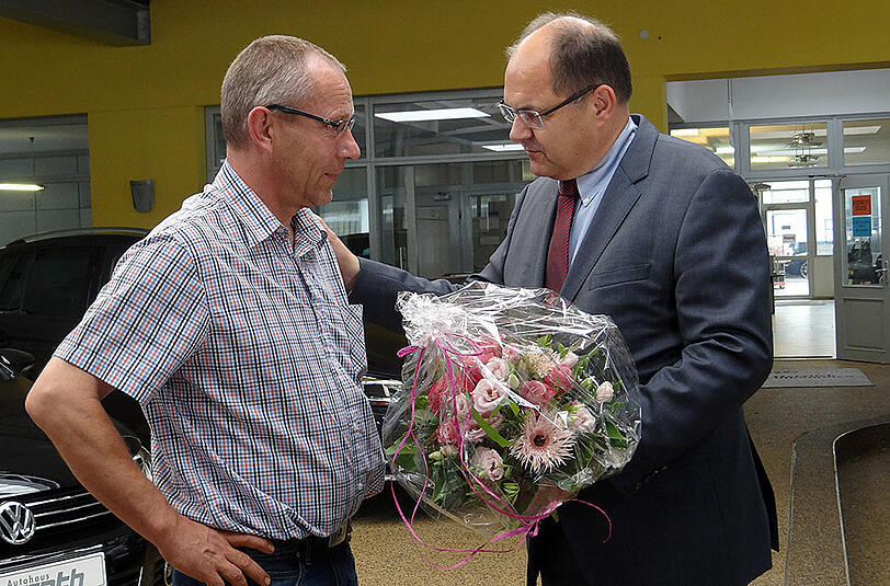 Bundesagrarminister Christian Schmidt (CSU - r) überreicht Frank Gurrath, dem Besitzer von Tankstelle und Autohaus in Bad Windsheim, einen Blumenstrauß. Nach der Amokfahrt mit zwei Toten in Mittelfranken schlägt Schmidt die Tankstellen-Mitarbeiter aus Bad Windsheim für eine Ehrung vor. Sie überwältigten den mutmaßlichen Schützen und hielten ihn fest, bis die Polizei kam.