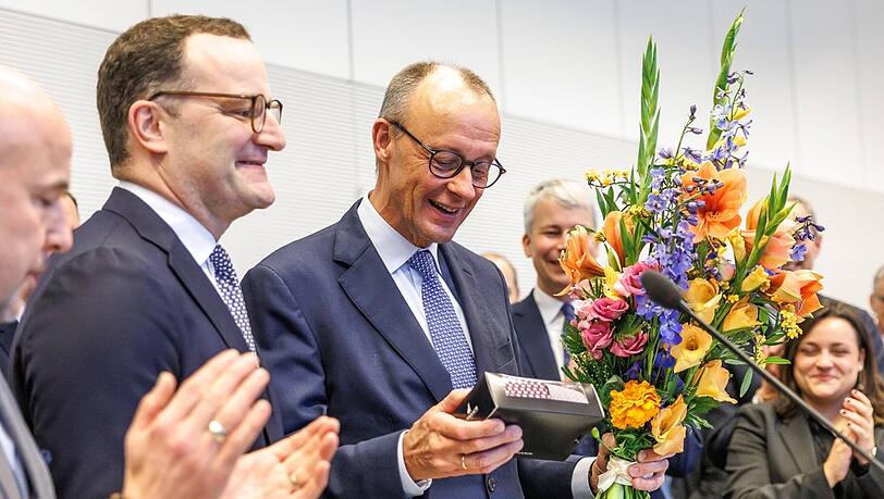 Jens Spahn (l.) überreicht Friedrich Merz zu seinem 70. Geburtstag neue Krawatten.