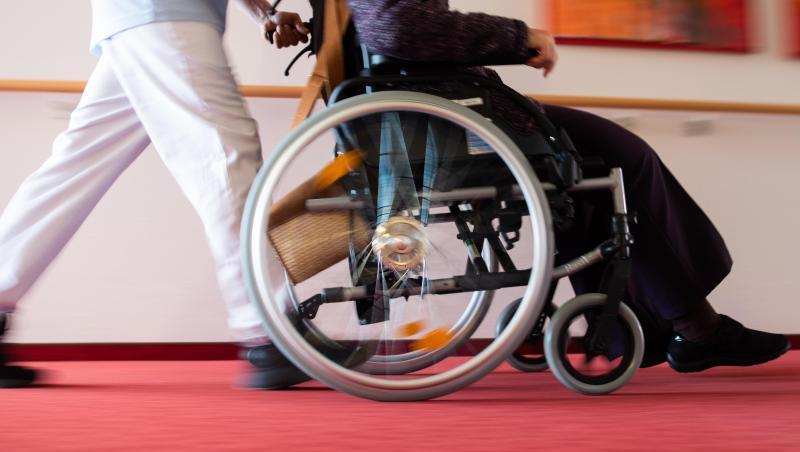 Ein Pfleger eines Pflegeheims schiebt eine Bewohnerin mit einem Rollstuhl. Foto: Tom Weller/dpa/Symbolbild Ein Pfleger eines Pflegeheims schiebt eine Bewohnerin mit einem Rollstuhl. Foto: Tom Weller/dpa/Symbolbild