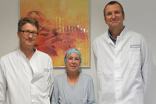 Renate M. ist gerettet. Mit der Patientin freuen sich Oberarzt Dr. Wolf Rösler (links) und Prof. Dr. Andreas Macksensen über den Therapieerfolg: &bdquo;ein kleines Wunder.